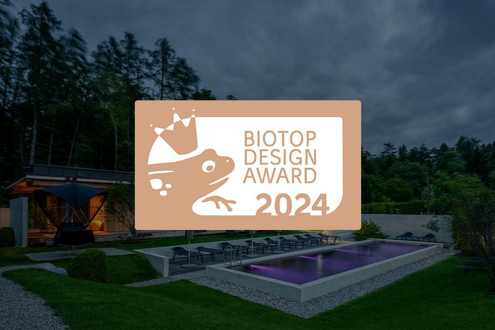 Grote biopool in de hoteltuin met ligstoelen en moderne architectuur