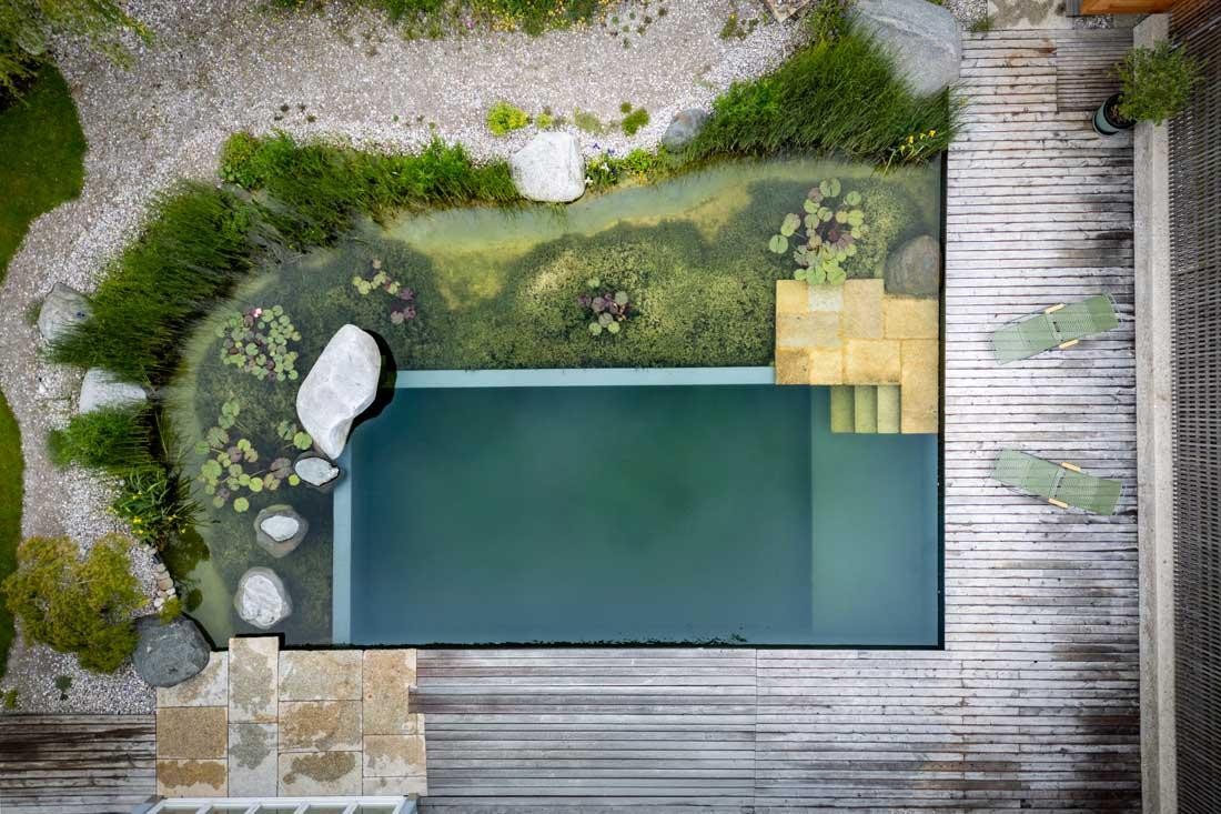 Luchtfoto van een natuurzwembad met regeneratiezone en houten terras