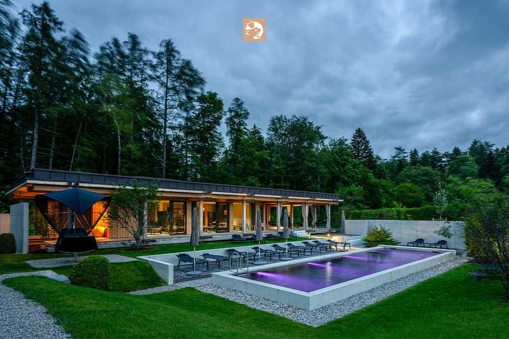 Biopool bij een hotel in de avond met verlichting en bosrijke achtergrond