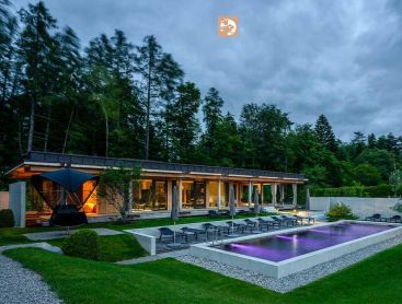 Biopool bij een hotel in de avond met verlichting en bosrijke achtergrond