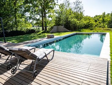 Natuurlijk zwembad in de tuin met houten terras