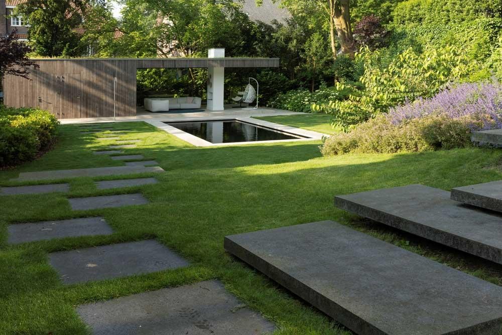 Natuurpool met terras, gazon en bloeiende tuinbeplanting