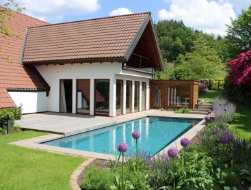 Natuurpool met rododendrons en bloeiende tuin