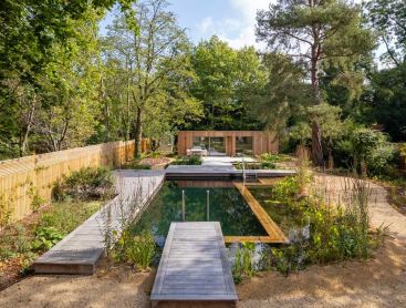 Omringd door grote bomen wordt deze Swimming Pond het middelpunt van de tuin