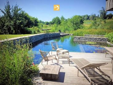 Een idyllische zwemvijver met een dromerig houten terras